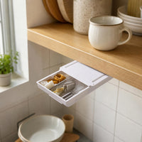 Tiroir HomeTuck ouvert sous une étagère de cuisine, avec un fouet et de petits ustensiles